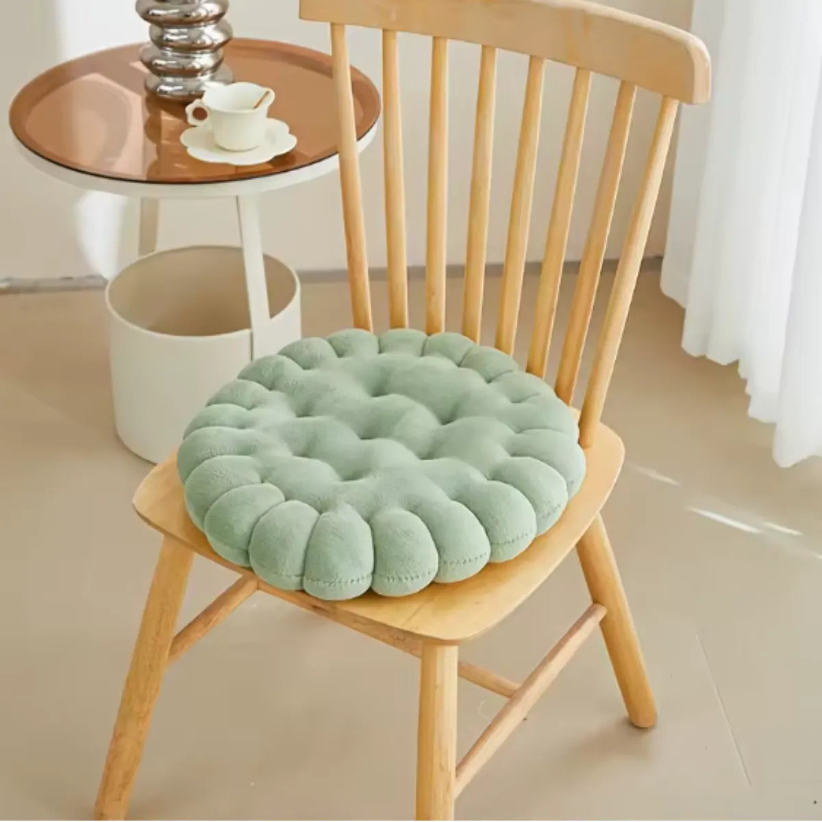 Coussin décoratif en forme de biscuit carré sur une chaise en bois à coté d'une petite table