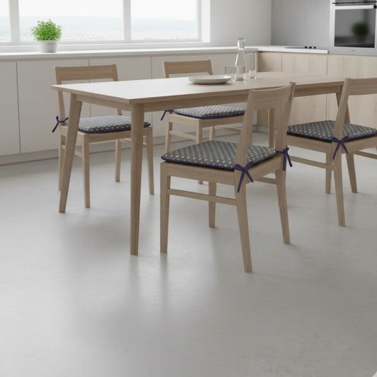Coussin de chaise confort, avec attaches, posé sur chaise en bois autour d’une table en bois.