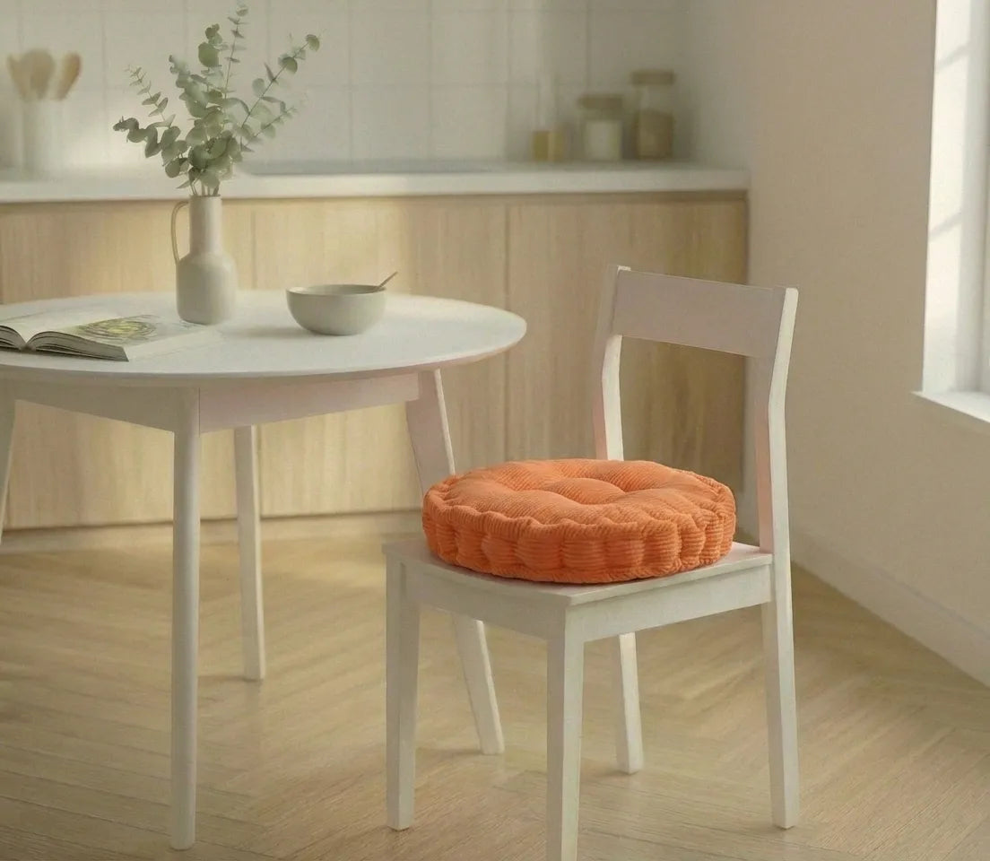 Chaise blanche avec un coussin de chaise épais à motifs côtelés, placée dans une cuisine lumineuse au sol en bois clair.